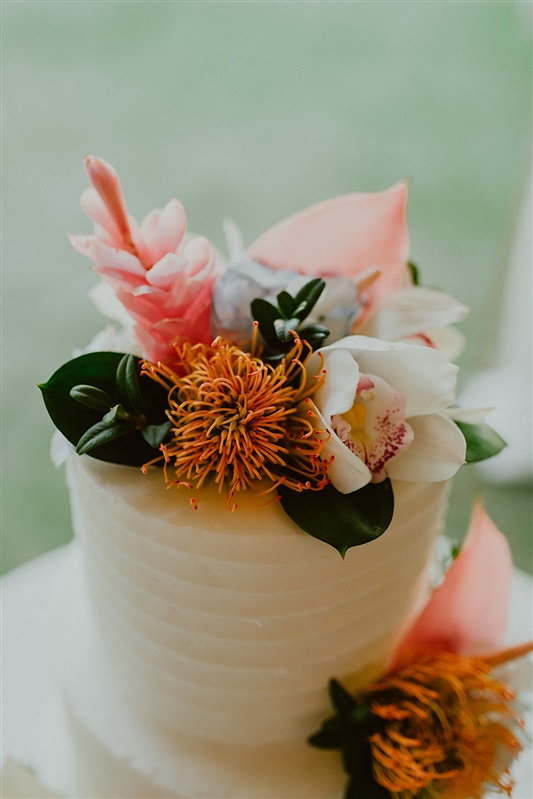 A simple but modern two tiered wedding cake with tropical flowers for decor | Seattle Wedding Photographer, Seattle Elopement Photographer, Seattle Elopement Inspiration, Civil Ceremony Wedding Ideas, Civil Ceremony Wedding Photographer | chelseaabril.com