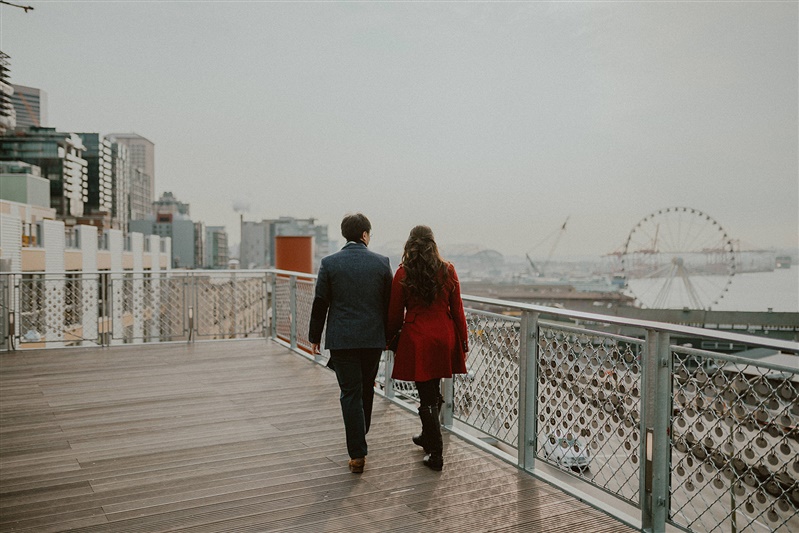 An newly engaged couple walk hand-in-hand in downtown Seattle for their engagement photos.