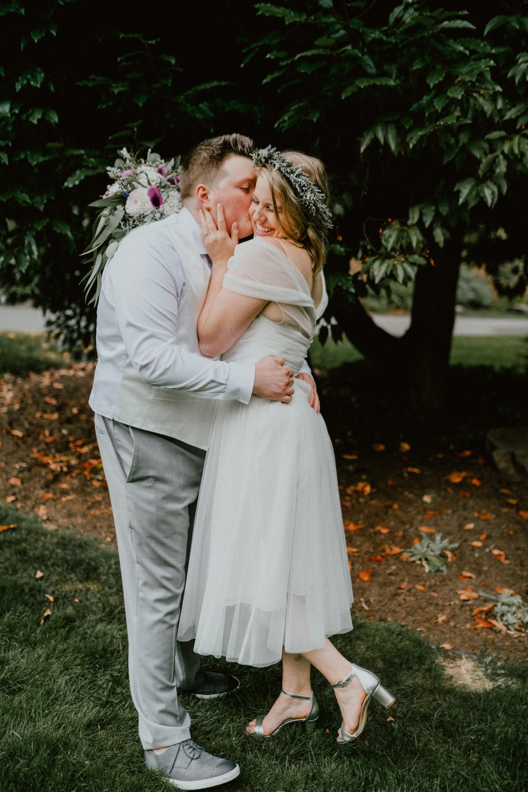 Bride and groom hug each other after backyard wedding, groom kisses bride on the cheek | Seattle Wedding Photographer, Seattle Elopement Photographer | chelseaabril.com