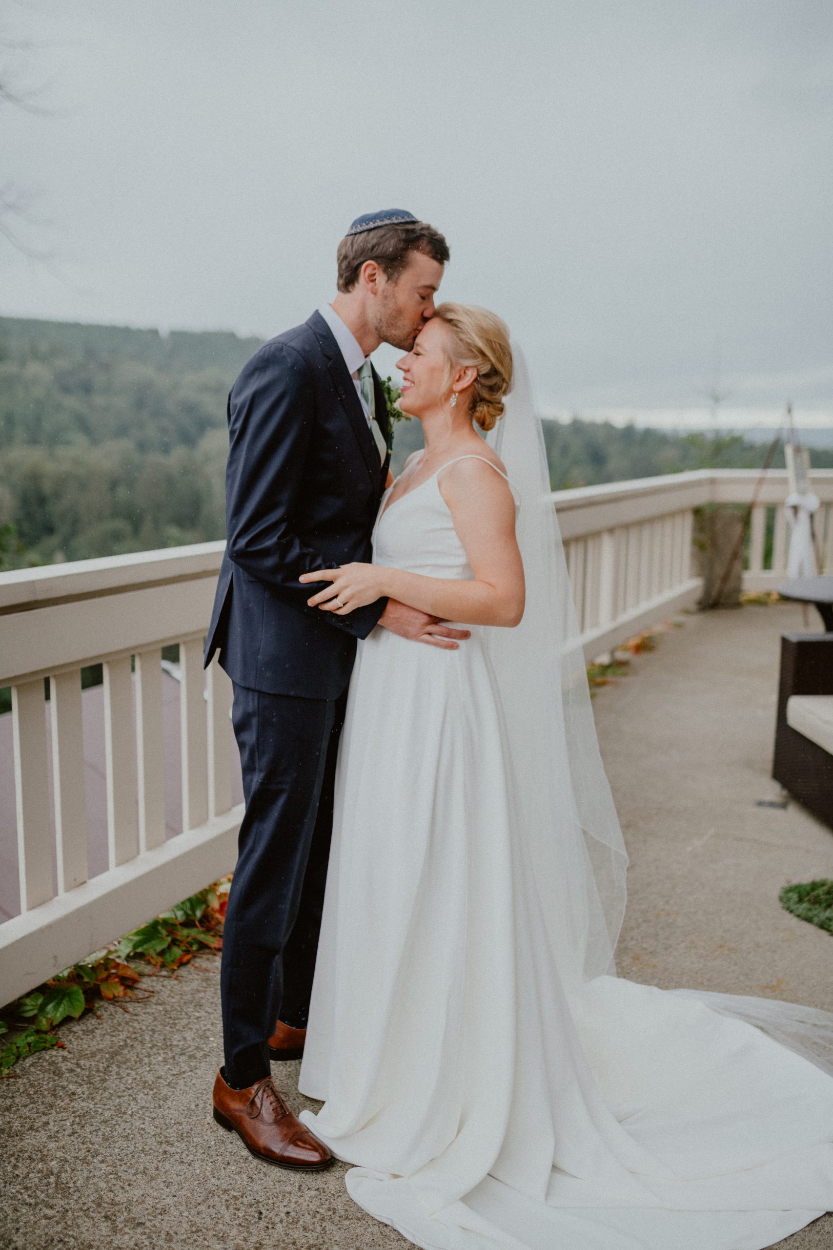 Groom kisses Bride on forehead in the rain after outdoor elopement wedding in Washington State, PNW wedding inspiration | Washington State Elopement Photographer, Seattle Elopement Photographer, Newlywed Elopement Photographer, Quarantine Wedding Elopement Inspiration | chelseaabril.com