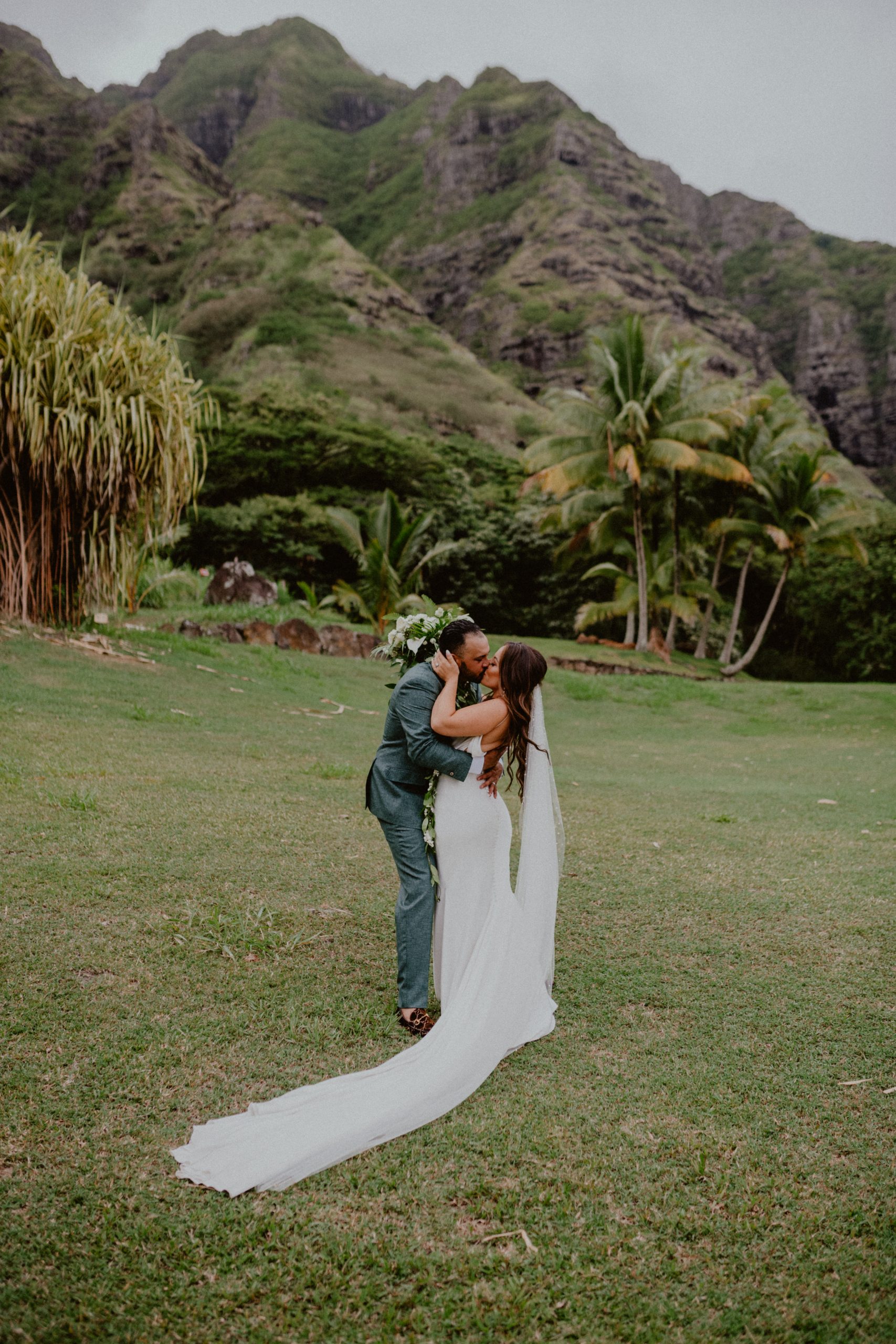 Bride and Groom kiss after their Kualoa Ranch Wedding in front of the mountains in Oahu | Oahu Wedding Photographer, Oahu Elopement Photographer, Destination Wedding Photographer, Destination Elopement Photographer, Newlywed moments ideas, Newlywed Photography inspiration, Hawaii Elopement ideas | chelseaabril.com