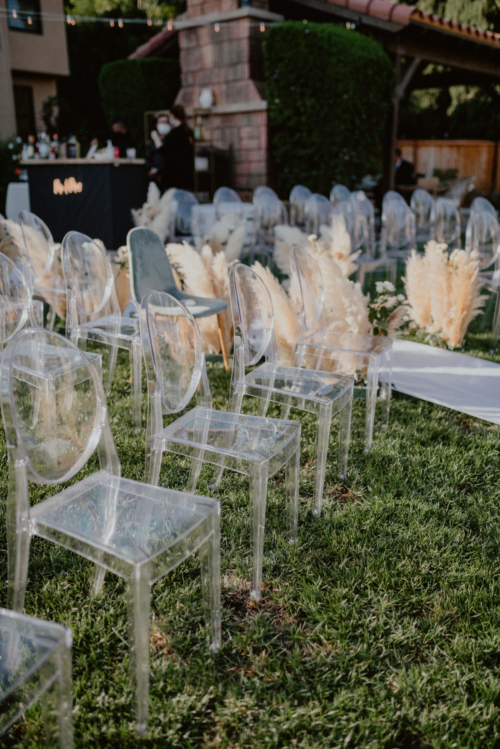 Pre-wedding ceremony set up with Pampas Grass and translucent chairs for wedding guests and a bar | San Diego Wedding Photographer, San Diego California Elopement Photographer, Destination Wedding Photographer, Destination Elopement Photographer, Newlywed moments ideas, Newlywed Photography inspiration, California Elopement ideas, San Diego Wedding Inspiration, Romantic Boho Wedding Ideas, Romantic Elopement Inspiration, Bohemian Wedding Ideas | chelseaabril.com