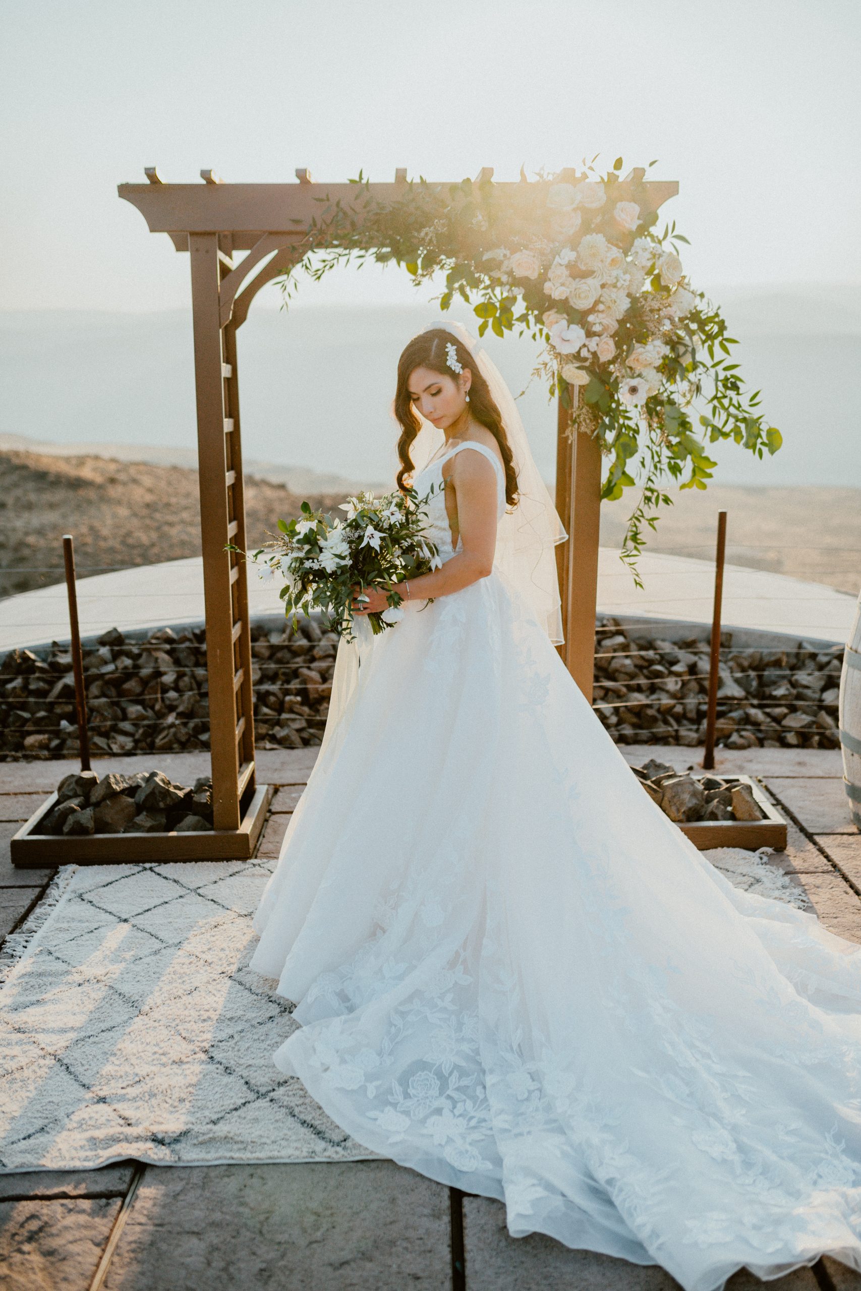 Wedding day style for bride, wears white floral lace with long train and veil bridal style holding white floral wedding bouquet | Washington Elopement, Destination Elopement Photographer, Cave B Inn Elopement Inspiration, Washington Elopement ideas, PNW Fall Wedding Inspiration, Fall Outdoor Wedding Ideas,Fall Wedding Inspiration, PNW Outdoor Wedding Ideas | chelseaabril.com