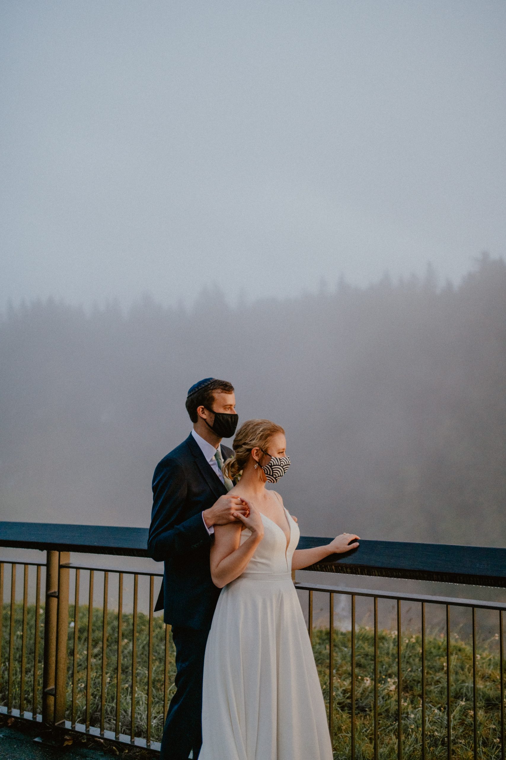 Bride and Groom in masks look out over the PNW wilderness | Seattle Elopement, Washington Elopement Photographer, Washington Elopement and Wedding Inspiration, Seattle Elopement ideas, PNW Wedding Inspiration, Fall Rainy PNW Wedding Ideas, Fall Wedding Inspiration, PNW Outdoor Wedding Ideas | chelseaabril.com