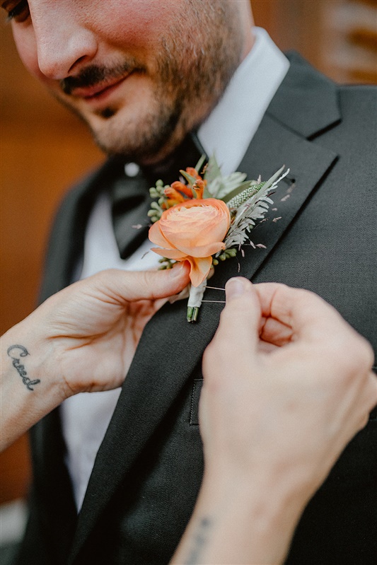 Mother of the bride photography helps groom fix his boutonniere of orange and green Fall floral inspiration | Sun River Elopement, Destination Elopement Photographer, Smith Rock Elopement Inspiration, Oregon Elopement ideas, PNW Fall Wedding Inspiration, Fall Outdoor Wedding Ideas,Fall Wedding Inspiration, PNW Outdoor Wedding Ideas | chelseaabril.com