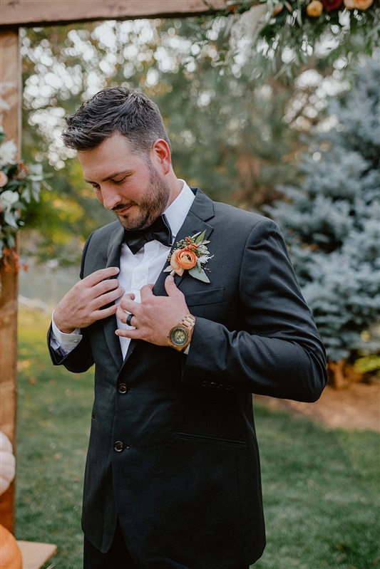 Groom stands in front of altar with a black tuxedo and black bow tie on wedding day groom style inspiration and ideas | Sun River Elopement, Destination Elopement Photographer, Smith Rock Elopement Inspiration, Oregon Elopement ideas, PNW Fall Wedding Inspiration, Fall Outdoor Wedding Ideas,Fall Wedding Inspiration, PNW Outdoor Wedding Ideas | chelseaabril.com