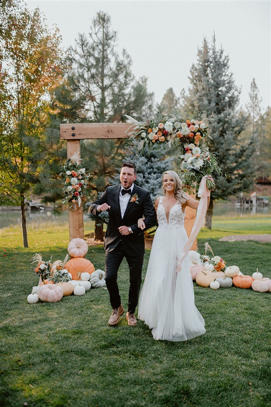 Bride and groom celebrate after vows and ceremony in Sun River destination elopement with fall wedding accents and fall floral inspiration | Sun River Elopement, Destination Elopement Photographer, Smith Rock Elopement Inspiration, Oregon Elopement ideas, PNW Fall Wedding Inspiration, Fall Outdoor Wedding Ideas,Fall Wedding Inspiration, PNW Outdoor Wedding Ideas | chelseaabril.com