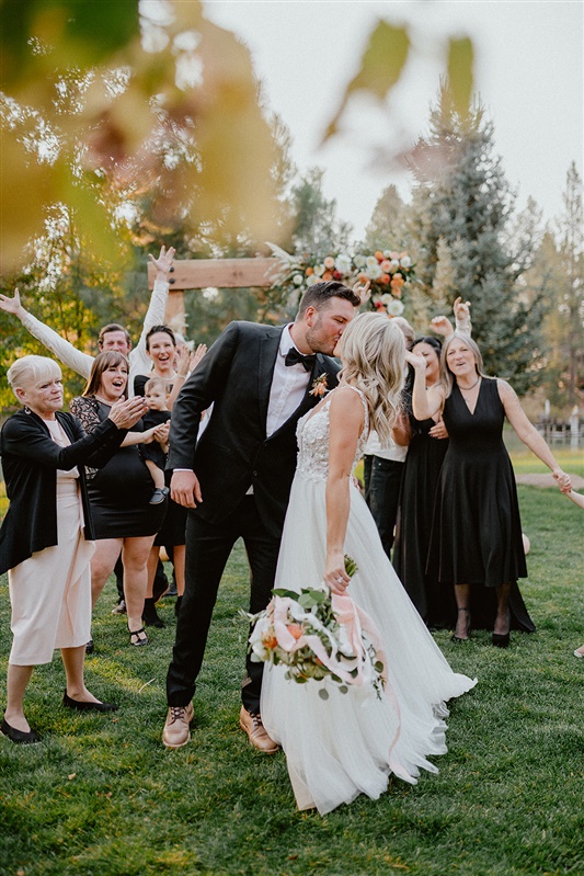 Bride and groom kiss in front of family after Fall PNW wedding ceremony in Sun River and Smith Rock destination ideas | Sun River Elopement, Destination Elopement Photographer, Smith Rock Elopement Inspiration, Oregon Elopement ideas, PNW Fall Wedding Inspiration, Fall Outdoor Wedding Ideas,Fall Wedding Inspiration, PNW Outdoor Wedding Ideas | chelseaabril.com
