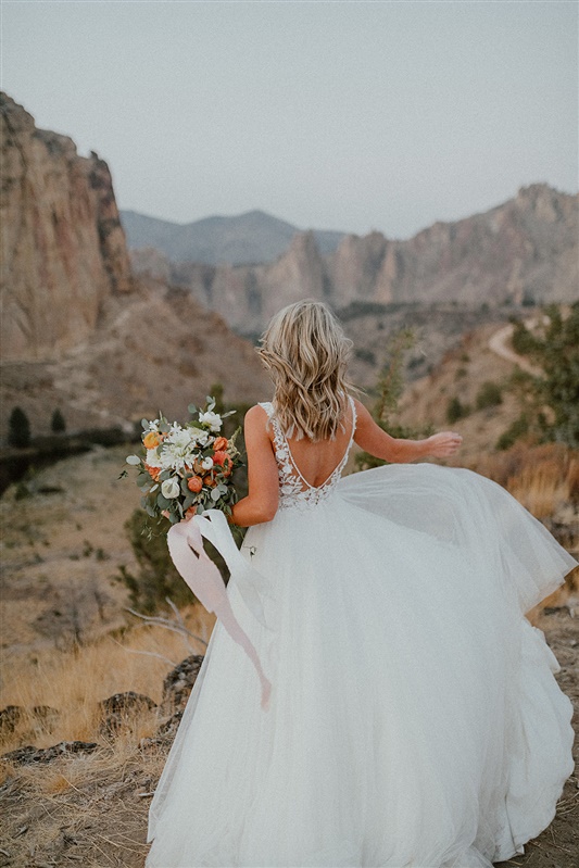Bride style photography in Smith Rock State park styled wedding shoot with Fall florals and Fall bridal gown inspiration | Sun River Elopement, Destination Elopement Photographer, Smith Rock Elopement Inspiration, Oregon Elopement ideas, PNW Fall Wedding Inspiration, Fall Outdoor Wedding Ideas,Fall Wedding Inspiration, PNW Outdoor Wedding Ideas | chelseaabril.com