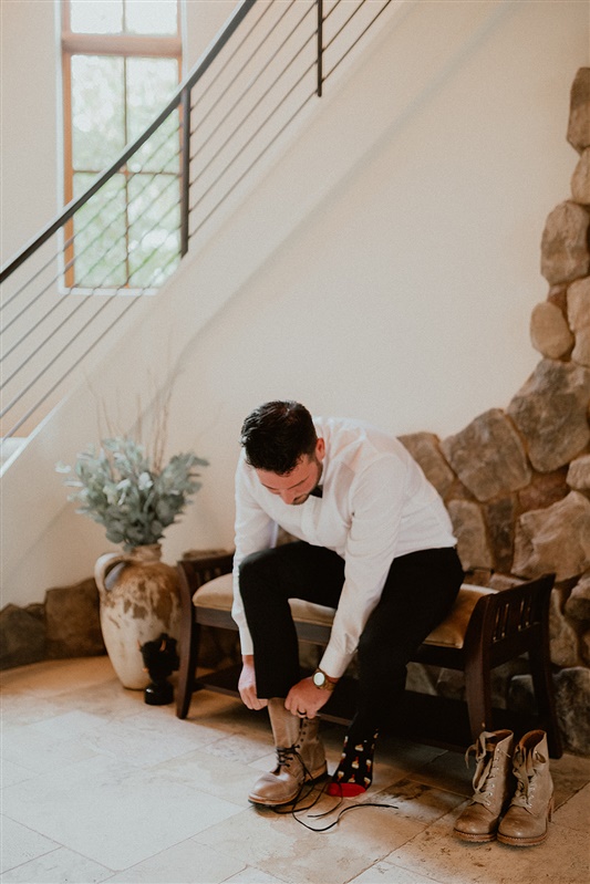 Pre-ceremony shot of groom putting on his shoes in the foyer while getting ready in groom style for Smith Rock wedding inspiration | Sun River Elopement, Destination Elopement Photographer, Smith Rock Elopement Inspiration, Oregon Elopement ideas, PNW Fall Wedding Inspiration, Fall Outdoor Wedding Ideas,Fall Wedding Inspiration, PNW Outdoor Wedding Ideas | chelseaabril.com