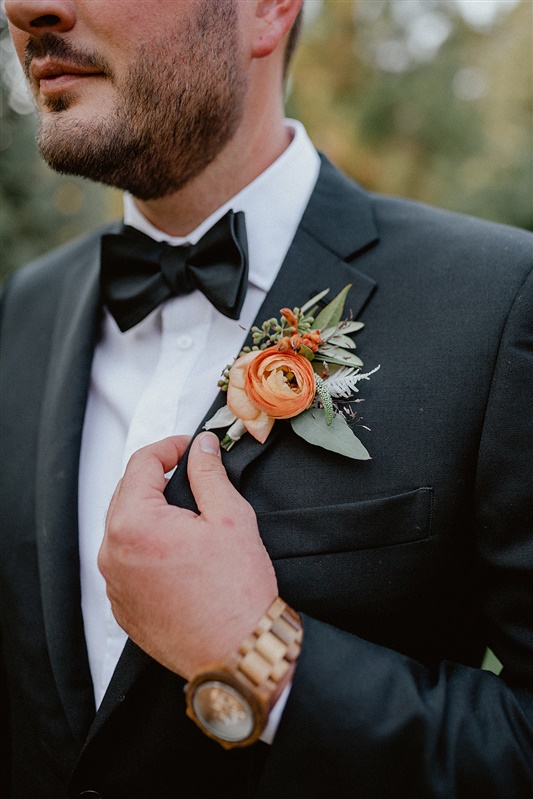 Close up shots of grooms boutonniere with orange and green Fall floral inspiration at PNW elopement with black bow tie and other groom style ideas | Sun River Elopement, Destination Elopement Photographer, Smith Rock Elopement Inspiration, Oregon Elopement ideas, PNW Fall Wedding Inspiration, Fall Outdoor Wedding Ideas,Fall Wedding Inspiration, PNW Outdoor Wedding Ideas | chelseaabril.com