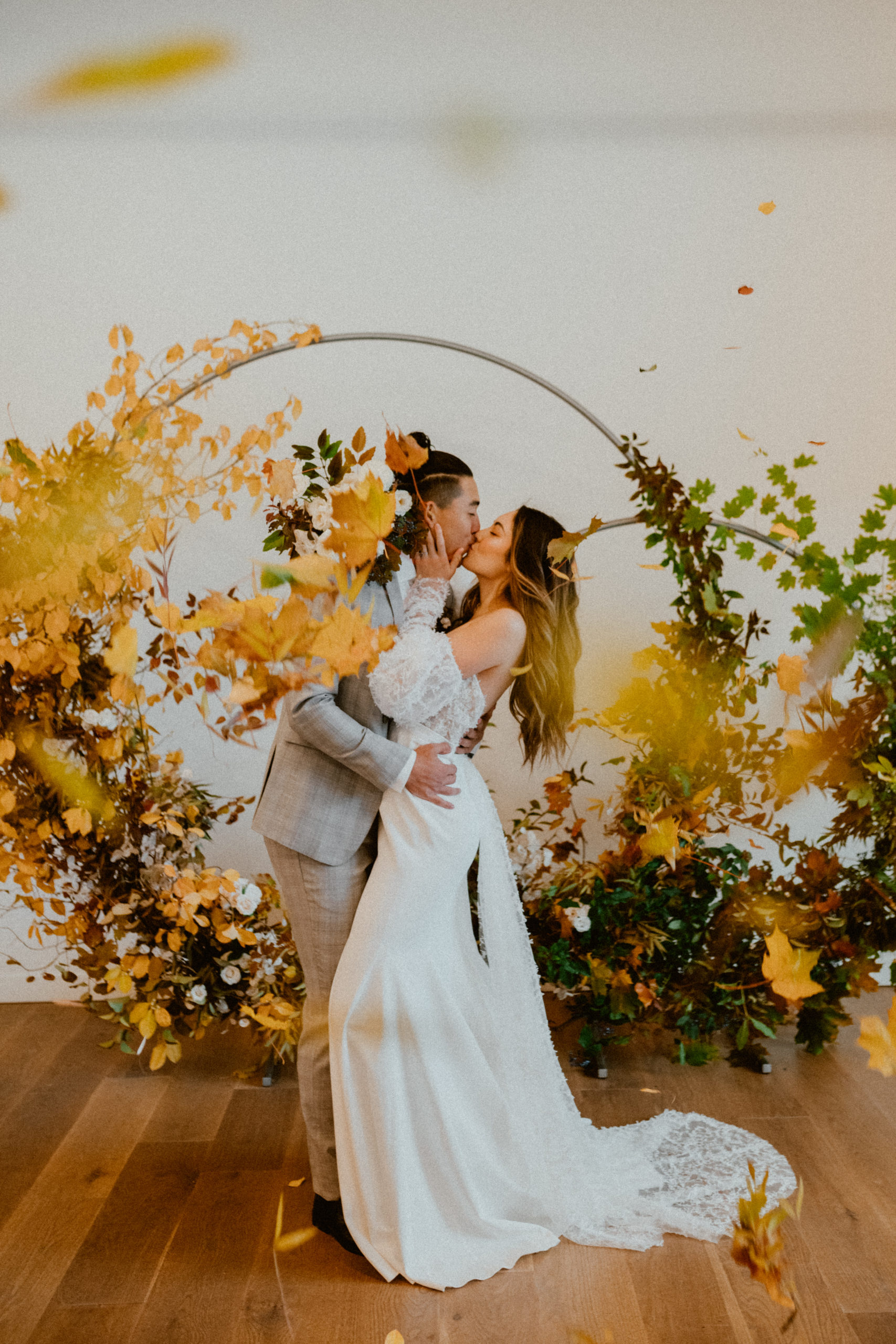 bride and groom kiss with arbor backdrop fall inspired wedding