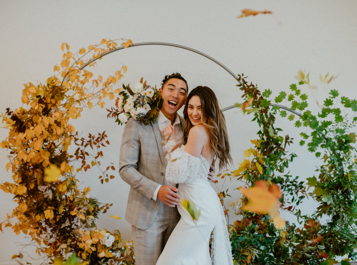 bride and groom with arbor backdrop fall inspired wedding