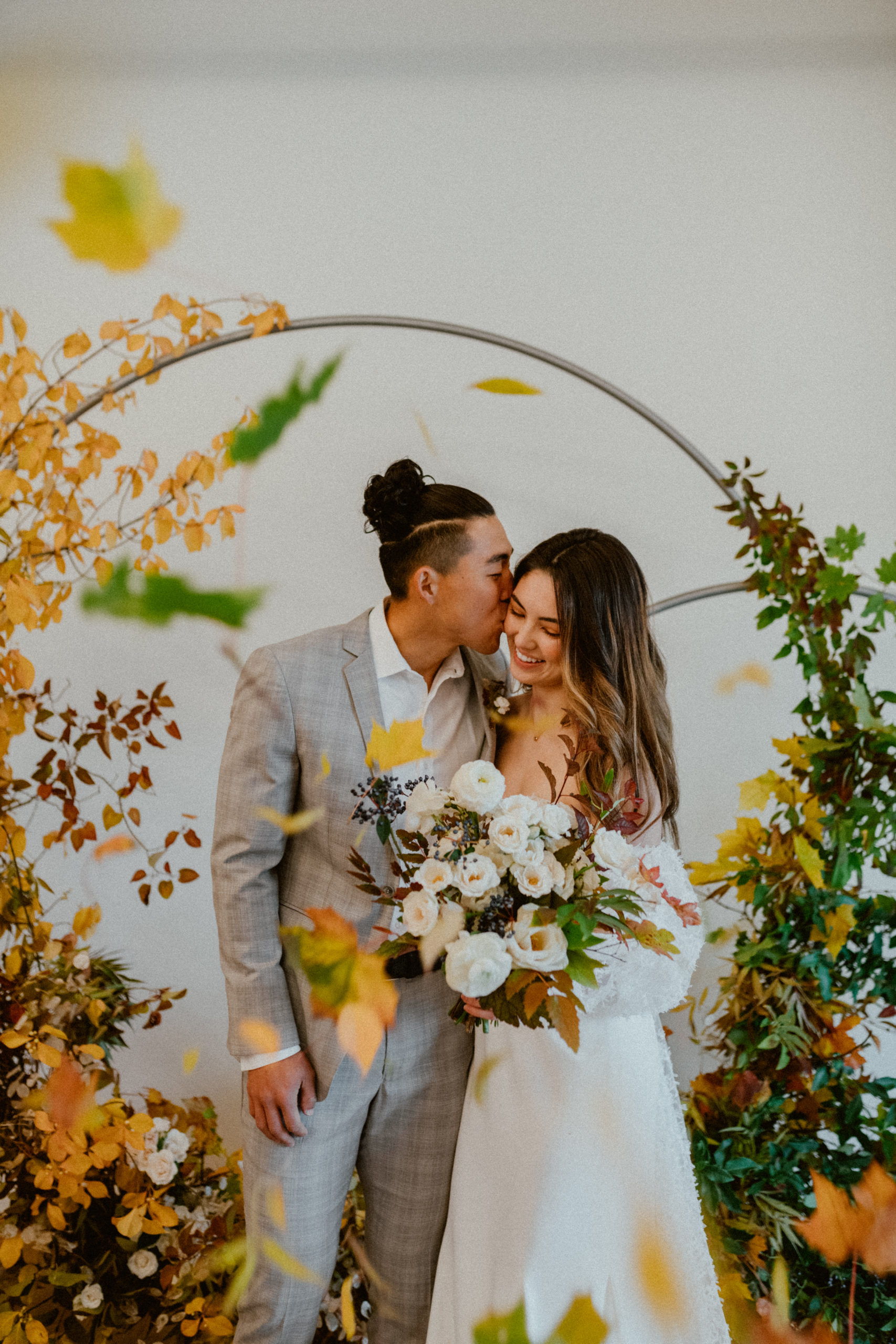 Bride and groom kiss in front of arbor fall inspired wedding