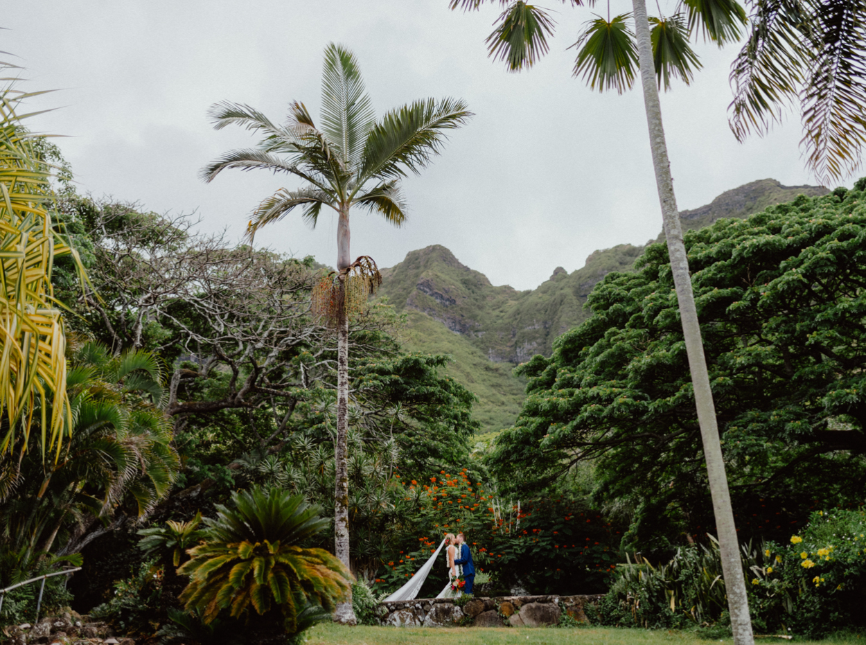 Bride Groom kiss in Paliku Gardens Kualoa Ranch with Koʻolau Range backdrop Jurassic park theme