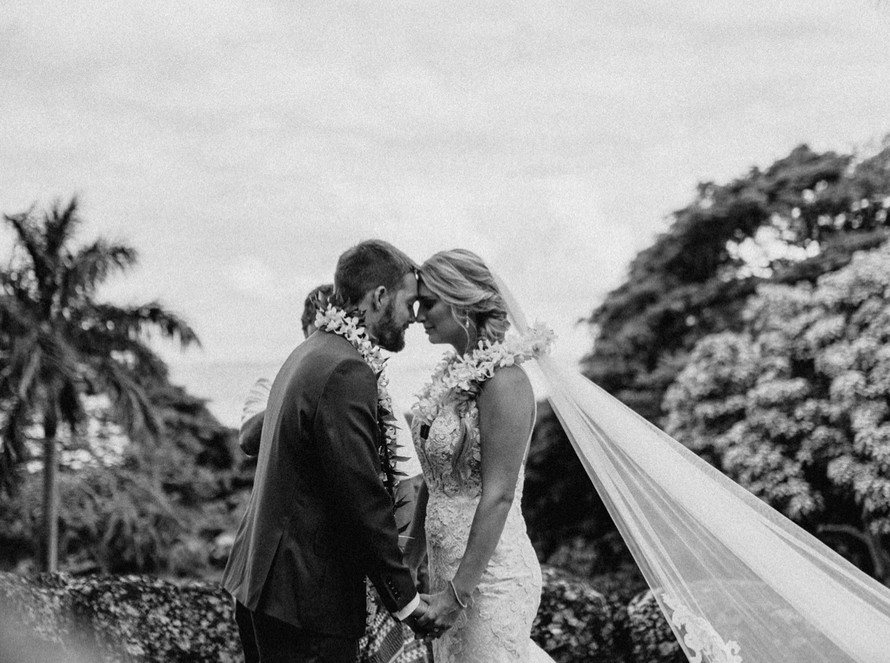 Lei exchange in Paliku Gardens Venue at Kualoa Ranch wedding with Chinaman's hat background