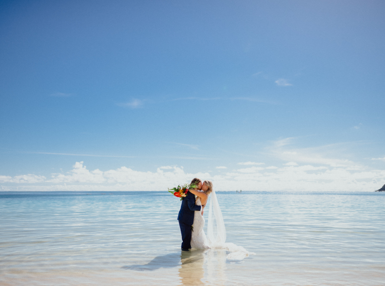 Bride and groom kiss  in Lanikai Beach